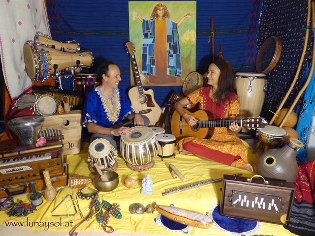 Patricia del Mar sitzt mit einem Musiker am Boden und macht Musik
