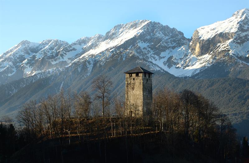 ein steinerner Turm vor einem Gebirge
